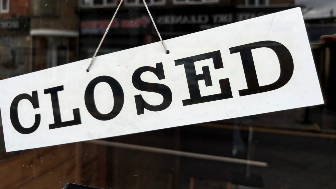 A closed sign hanging on a shop's window